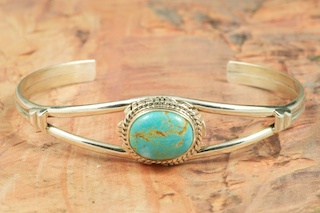 Genuine Number 8 Mine Turquoise set in Sterling Silver Bracelet. Created by Navajo Artist Larson Lee. Signed.  The Number 8 mine is located in Eureka County Nevada. Since 1976 there has been no Number 8 Turquoise mined. There is however, an existing stock pile that Mr. Dowell Ward, the last owner of the Number 8 mine, had stocked away for later sorting. The Turquoise is a collector's item--because once the reserve is gone there will be no more material released onto the market. The Gold Mining Company owns the claim to the Number 8 mine and it has been swallowed up by the gold mining operations. This is some of the last Number 8 Turquoise to be had and will be a great addition to your collection. 